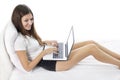 Beautiful young girl working on her laptop at bedroom Royalty Free Stock Photo