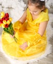 Beautiful young girl in yellow dress holding flowers Royalty Free Stock Photo