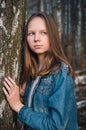 Beautiful young girlin a denim jacket in an autumn park