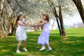 Young girls with blue eyes in white dresses in garden with apple trees blosoming Royalty Free Stock Photo