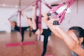 Beautiful young girls doing fly yoga on hammocks, stretching legs, taking care of health