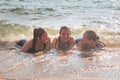 Waves Splash Girls Laying on the Sand Royalty Free Stock Photo