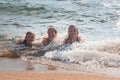 Waves Splash Girls Laying on the Sand Royalty Free Stock Photo