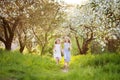 Beautiful young girls in long dresses in the garden with blosoming  apple trees. Smiling girls runing, having fun and enjoying Royalty Free Stock Photo