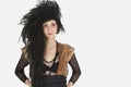 Beautiful young Goth woman with teased hair looking away over gray background Royalty Free Stock Photo