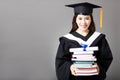 Beautiful young graduate holding diploma and book