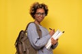 African american woman with backpack ready to study, writing some notes. Royalty Free Stock Photo