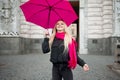 Beautiful young and happy blond woman with colorful umbrella on the street. The concept of positivity and optimism Royalty Free Stock Photo