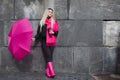 Beautiful young and happy blond woman with colorful umbrella on the street. The concept of positivity and optimism Royalty Free Stock Photo