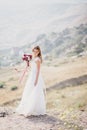 Beautiful young happy bride standing on the top of the mountain Royalty Free Stock Photo