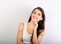 Beautiful young happy casual woman with finger under the face thinking and looking up in white shirt and long hair. Closeup Royalty Free Stock Photo