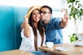 Young happy couple doing selfie in a cafe Royalty Free Stock Photo