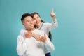 Beautiful young happy couple love smiling embracing point finger to empty copy space, man and woman smile looking up Royalty Free Stock Photo