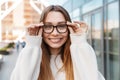 Beautiful young happy excited business woman posing walking outdoors near business center wearing eyeglasses Royalty Free Stock Photo