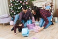 Beautiful young happy family caucasian mother father and kid in plaid shirt and jeans playing near christmas tree and fireplace Royalty Free Stock Photo