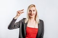 Beautiful young happy girl showing small size gesture on gray isolated background Royalty Free Stock Photo