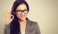 Beautiful young happy success business woman in eyeglasses showing ok cool sign by hand and looking. Closeup Royalty Free Stock Photo