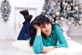 Beautiful young woman lying on the floor indoors in a christmas Royalty Free Stock Photo