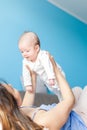 Beautiful young happy woman play with her newborn baby lies on t Royalty Free Stock Photo