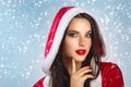 Beautiful young happy woman in Santa Claus clothes over Christmas background. Smiling woman over white background. beauty portrait