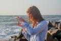 Beautiful young happy woman in sunglasses playing with seashell in her hands Royalty Free Stock Photo