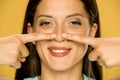 Beautiful young happy woman touching her nose with her fingers Royalty Free Stock Photo