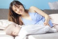 Beautiful young happy woman with her newborn baby lies on the couch, family love and care concept Royalty Free Stock Photo