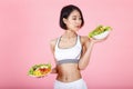 Beautiful young healthy woman with salad bowl isolated over pink background. Fitness Diet and healthy eating concept Royalty Free Stock Photo