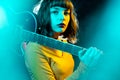 Beautiful young hipster woman with curly hair with red guitar in neon lights. Rock musician is playing electrical guitar Royalty Free Stock Photo