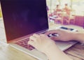 beautiful young hipster woman`s hands busy working on her laptop sitting at wooden table in a coffee shop Royalty Free Stock Photo