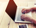 beautiful young hipster woman`s hands busy working on her laptop sitting at wooden table in a coffee shop Royalty Free Stock Photo