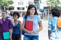 Beautiful young hispanic female student with group of young adults Royalty Free Stock Photo