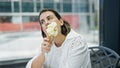 Beautiful young hispanic woman eating ice cream at cafeteria Royalty Free Stock Photo