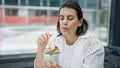 Beautiful young hispanic woman eating ice cream at cafeteria Royalty Free Stock Photo