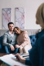 Beautiful young husband and wife are visiting a psychologist. Sitting and embracing. Royalty Free Stock Photo