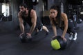 Beautiful young indian sports couple is working out with medicine ball in gym