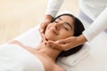 Beautiful young indian woman enjoying face lifting massage in spa Royalty Free Stock Photo