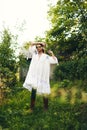 Beautiful young Indian woman smelling flower in the park, wearing white dress Royalty Free Stock Photo