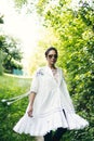 Beautiful young Indian woman smelling flower in the park, wearing white dress Royalty Free Stock Photo