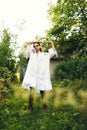 Beautiful young Indian woman smelling flower in the park, wearing white dress Royalty Free Stock Photo