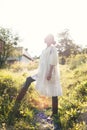 Beautiful young Indian woman smelling flower in the park, wearing white dress Royalty Free Stock Photo