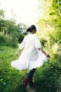 Beautiful young Indian woman smelling flower in the park, wearing white dress Royalty Free Stock Photo