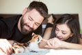 Beautiful young inlove couple on the bed playing with a kitten