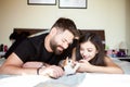 Beautiful young inlove couple on the bed playing with a kitten