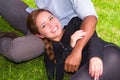 Beautiful young interracial couple in sitting garden environment, embracing and smiling happily to camera Royalty Free Stock Photo