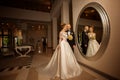 Beautiful young just merried couple posing in front of a large mirror