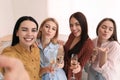 Beautiful ladies with champagne taking selfie at home. Women`s Day