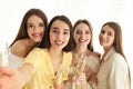 Beautiful young ladies with champagne taking selfie. Woman`s Day