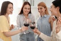 Beautiful ladies clinking glasses of wine in kitchen. Women`s Day