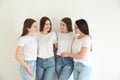 Beautiful young ladies in jeans and white t-shirts on background. Woman`s Day Royalty Free Stock Photo